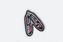 Load image into Gallery viewer, A patch with two formline black feathers with red and white accents, on a white background. It has black binding on the edges.