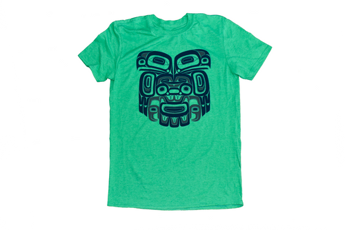 A green t-shirt featuring a navy colored formline design of Eagle