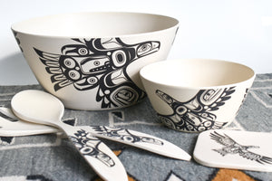 A picture of all four eagle items. A large bowl in the back, a small bowl to its left, a coaster in the lower right corner and the serveware crossed and to the left of the bowls.